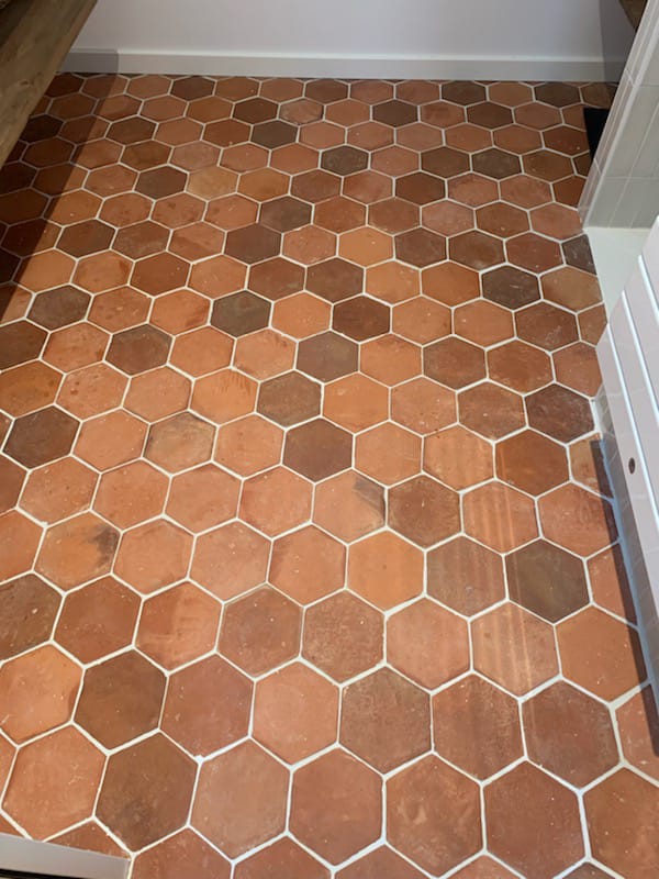Carrelage en tomettes rouges typiques, posé dans une entrée rénovée