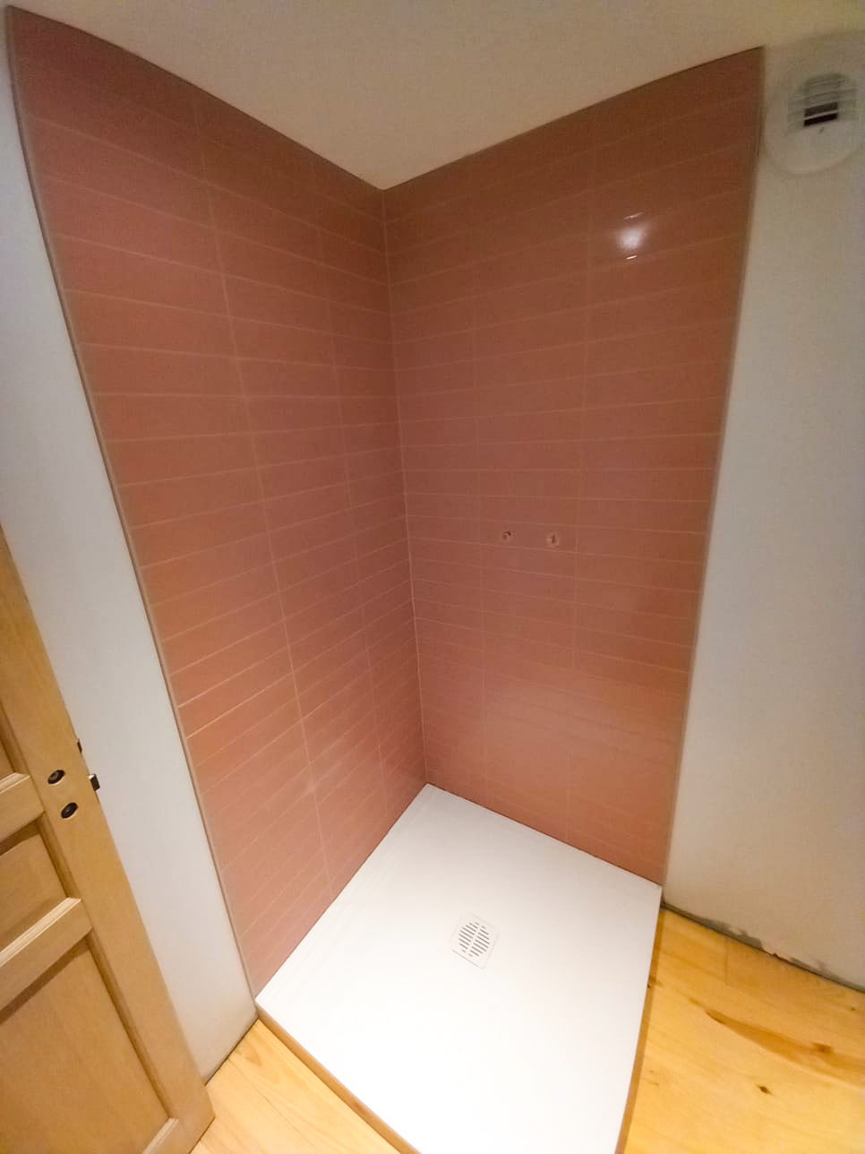 Douche avec carrelage mural rose saumon posé avec précision